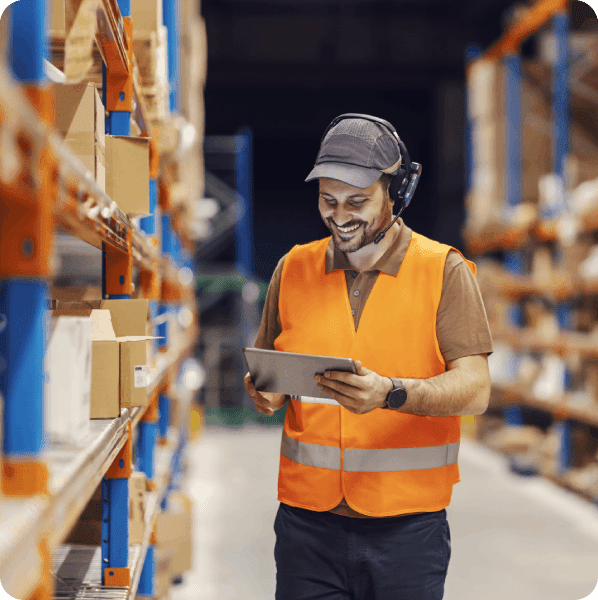 Warehouse worker using tablet in a warehouse.