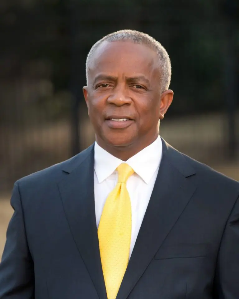 A man in a suit and tie standing outside.